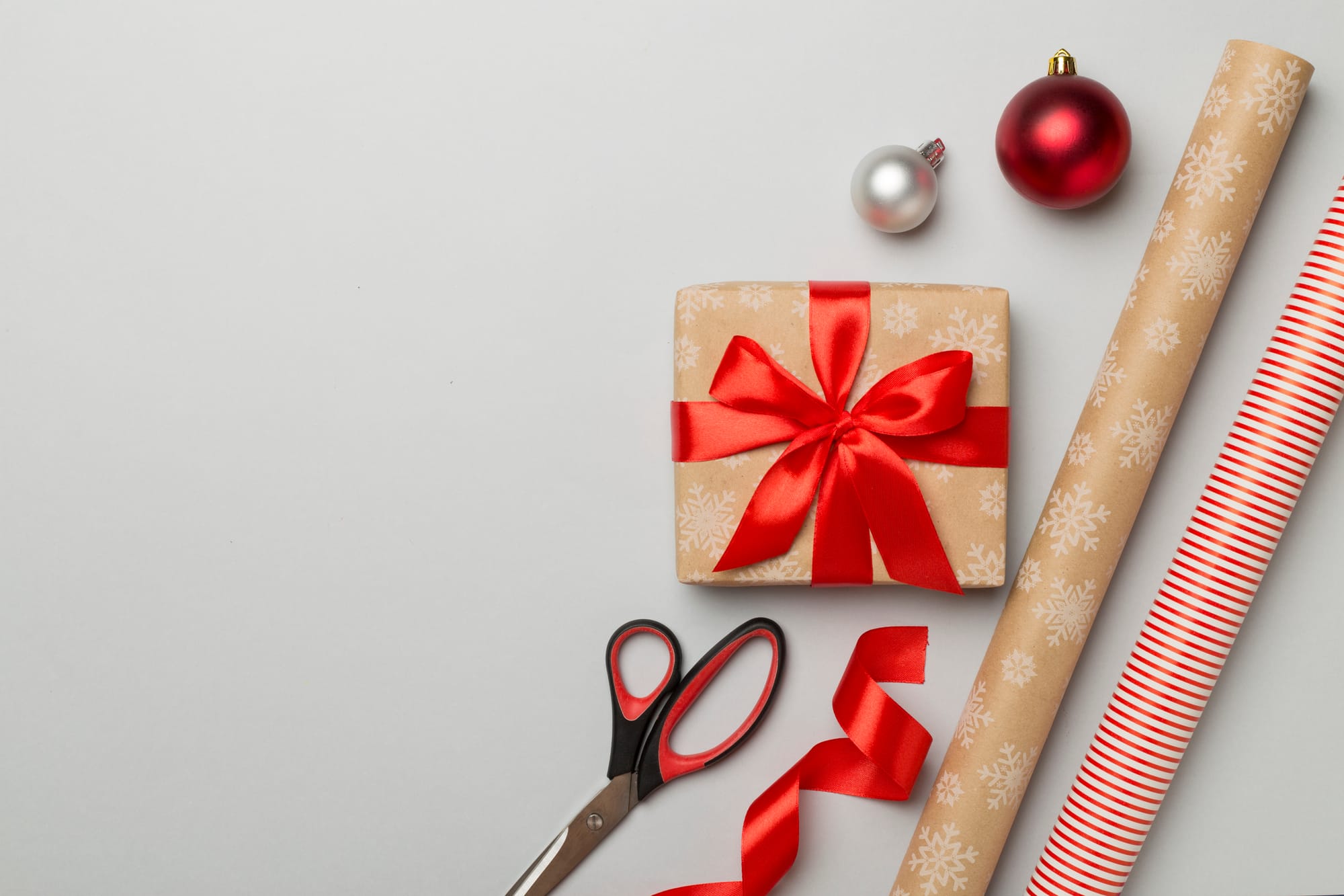 Gift boxes, paper's rolls and decorations on color background, top view.