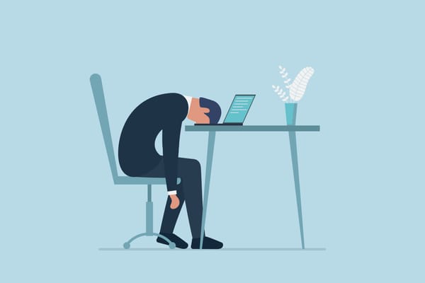 Exhausted male sitting with head down on laptop. Frustrated worker mental health problems.